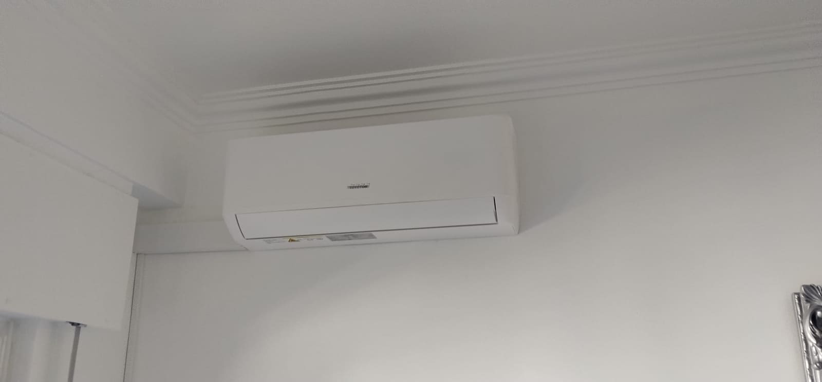 Ar condicionado mural instalado junto ao teto de um quarto